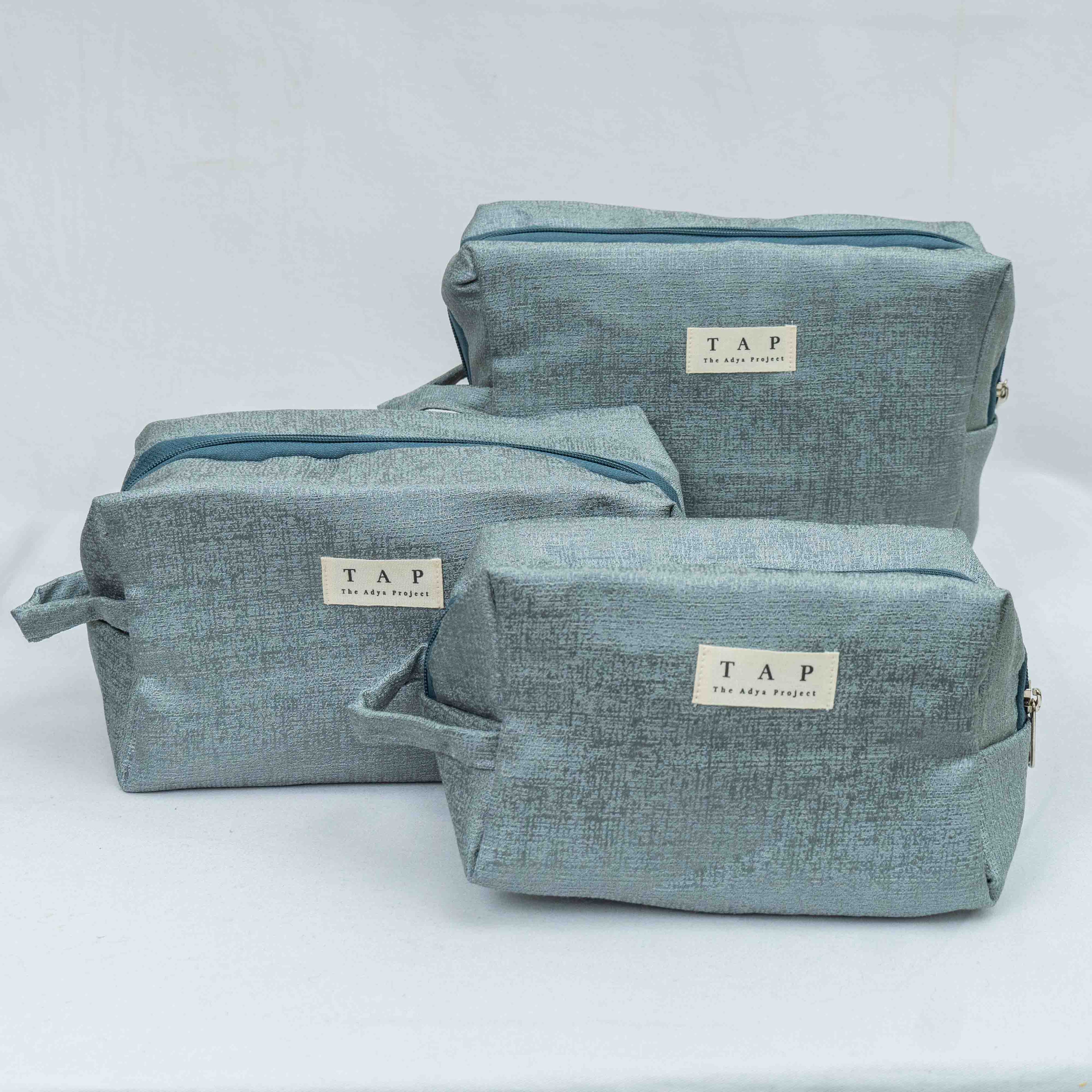 Set of three blue fabric bags with 'TAP' branding on a white background