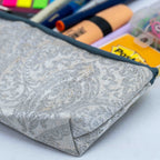 Gray fabric pouch with stationery items in the background