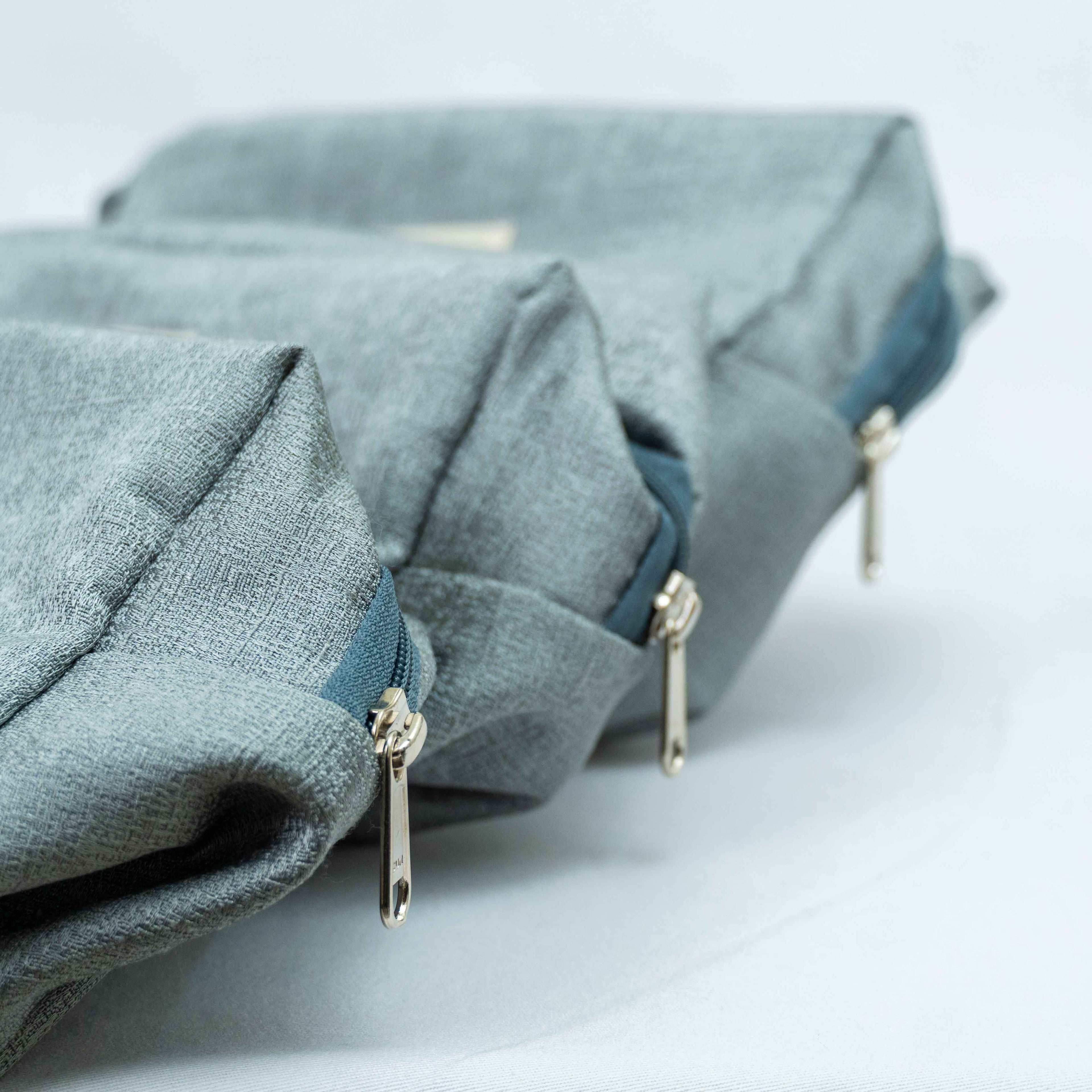 Folded blue fabric with zippers on a light gray background