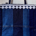 Blue denim bag with white lace trim on a white background