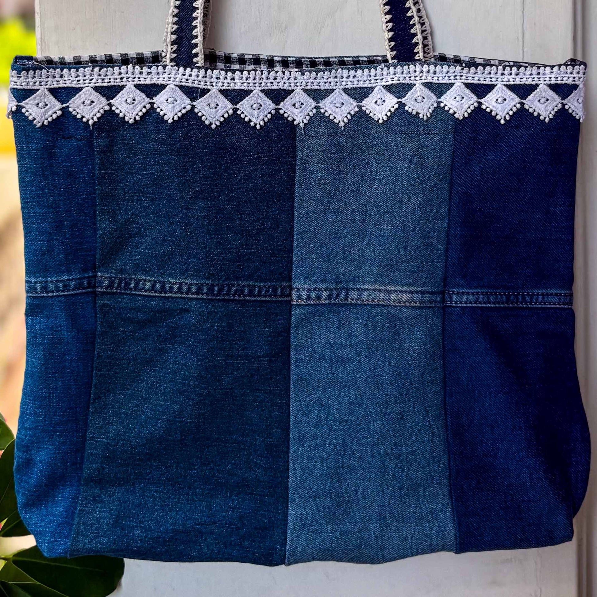 Blue denim tote bag with white embroidery on a light background