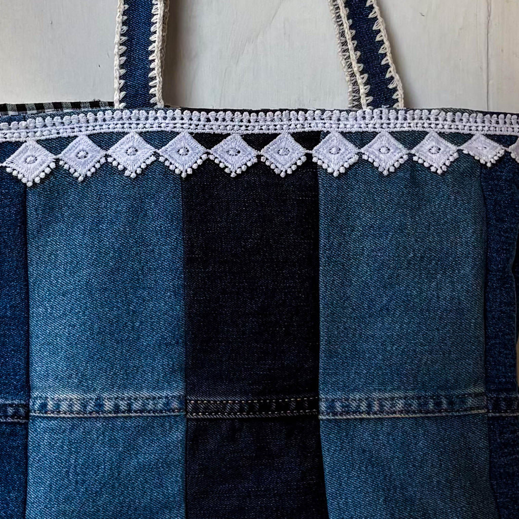 Denim apron with white lace trim on a white background