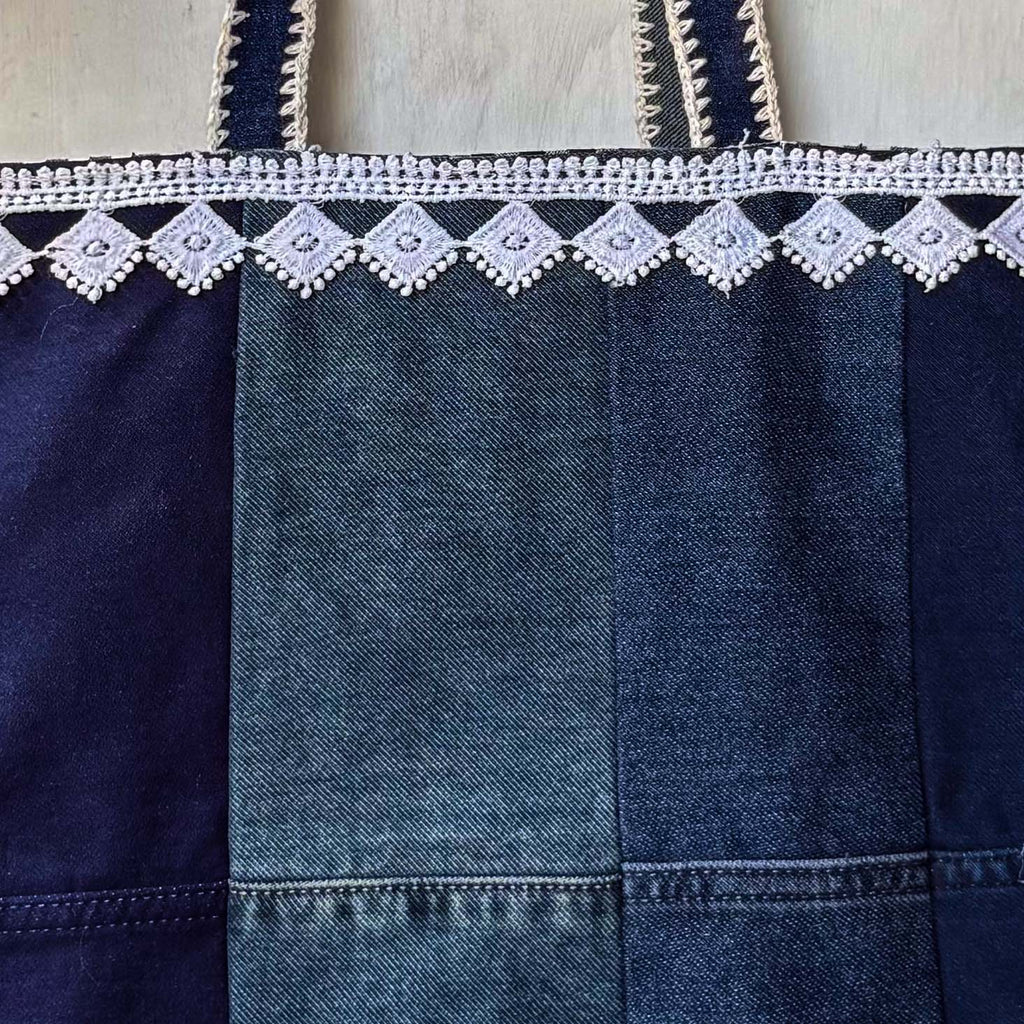Denim bag with lace trim on a wooden surface