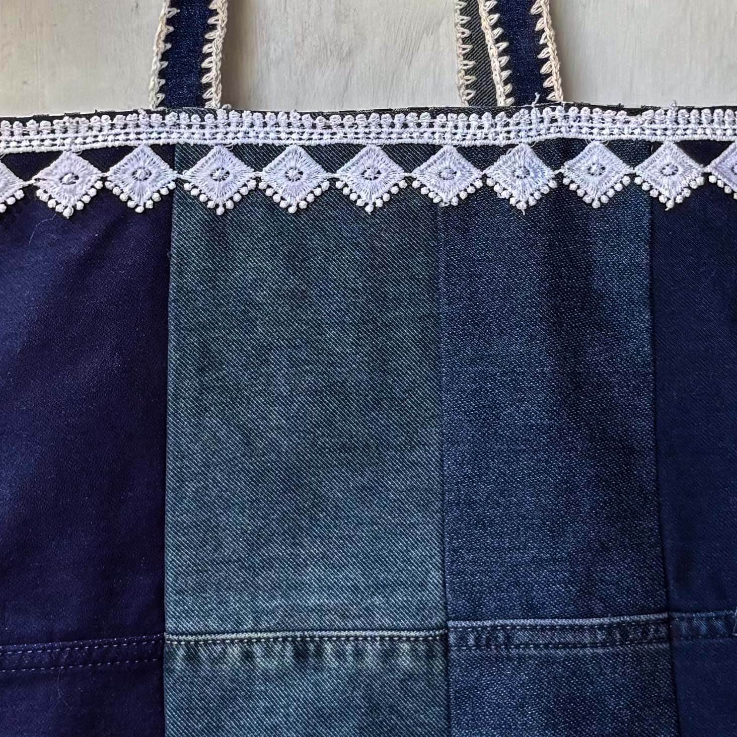 Denim bag with lace trim on a wooden surface